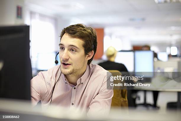 young man in call centre office - centre dappel photos et images de collection