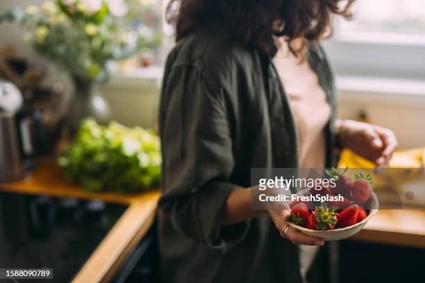 an unrecognizable beautiful woman eating strawberries - strawberry stock pictures, royalty-free photos & images