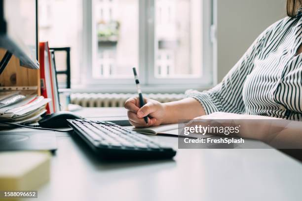 anonymous plus size businesswoman writing a report on a desktop pc in her office - administrative professional stock pictures, royalty-free photos & images
