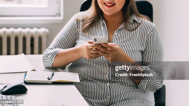 anonymous female office worker being distracted at work, using their phone to check social media - administrative professional stock pictures, royalty-free photos & images