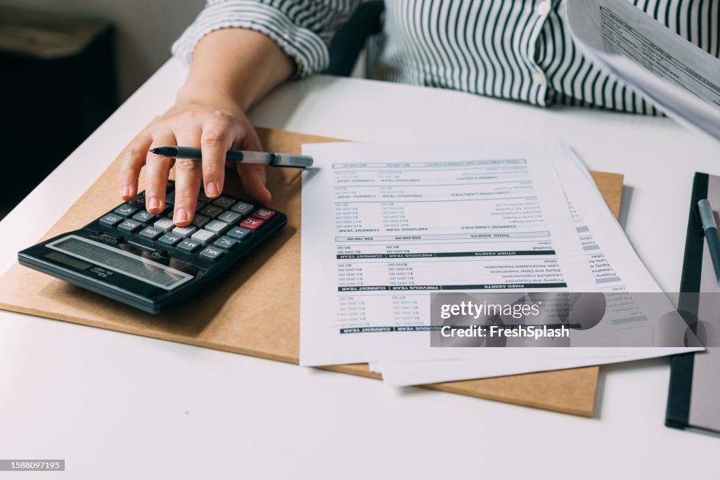 Unrecognizable Female Accountant Analyzing the Company's Financial Records