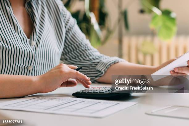 anonymous businesswoman analyzing financial reports using a calculator - check financial item stock pictures, royalty-free photos & images