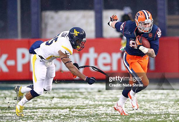 Beckett Wales of the Syracuse Orange runs the ball against Darwin Cook of the West Virginia Mountaineers during the New Era Pinstripe Bowl at Yankee...