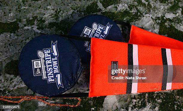 Down markers are seen laying on the field in snow with the New Era Pinstripe Bowl logo during the game between the Syracuse Orange and the West...