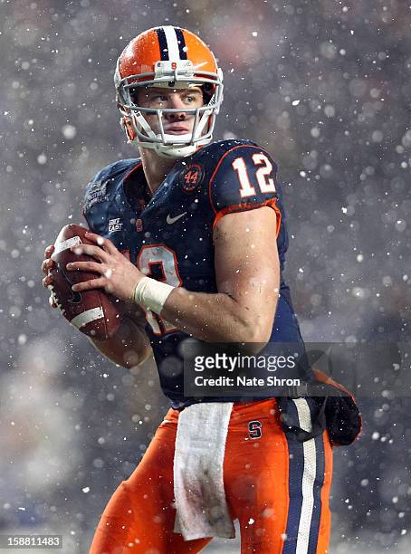 Quarterback Ryan Nassib of the Syracuse Orange prepares to pass against the West Virginia Mountaineers during the New Era Pinstripe Bowl at Yankee...