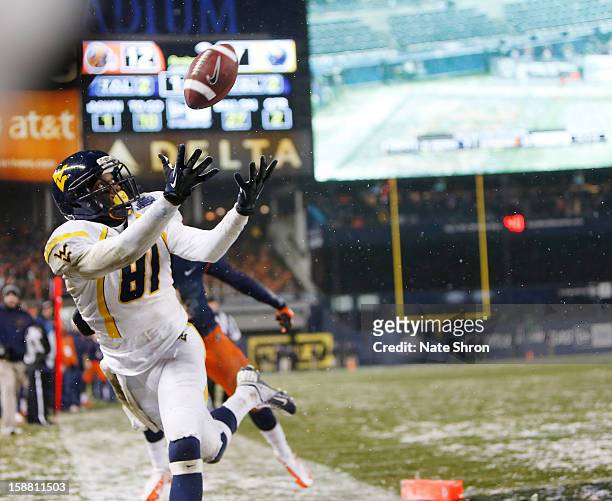 Woods of the West Virginia Mountaineers attempts to complete a pass aginast the Syracuse Orange during the New Era Pinstripe Bowl at Yankee Stadium...