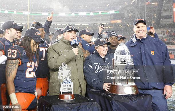 Head coach Doug Marrone of the Syracuse Orange stands with teamates as they receive the trophy after their win over the West Virginia Mountaineers...