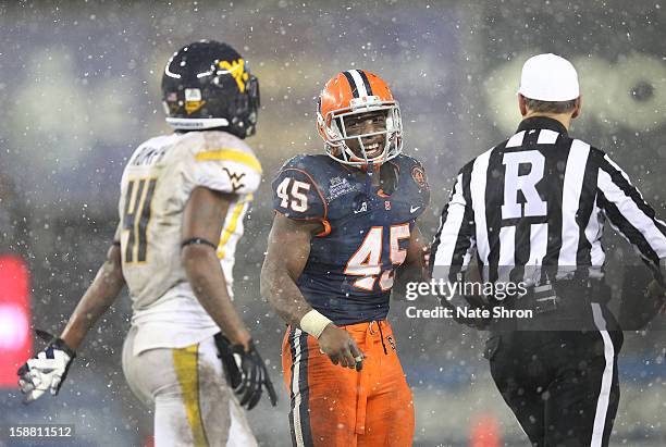 Jerome Smith of the Syracuse Orange smiles towards Ricky Rumph of the West Virginia Mountaineers as they walk off the field during the New Era...