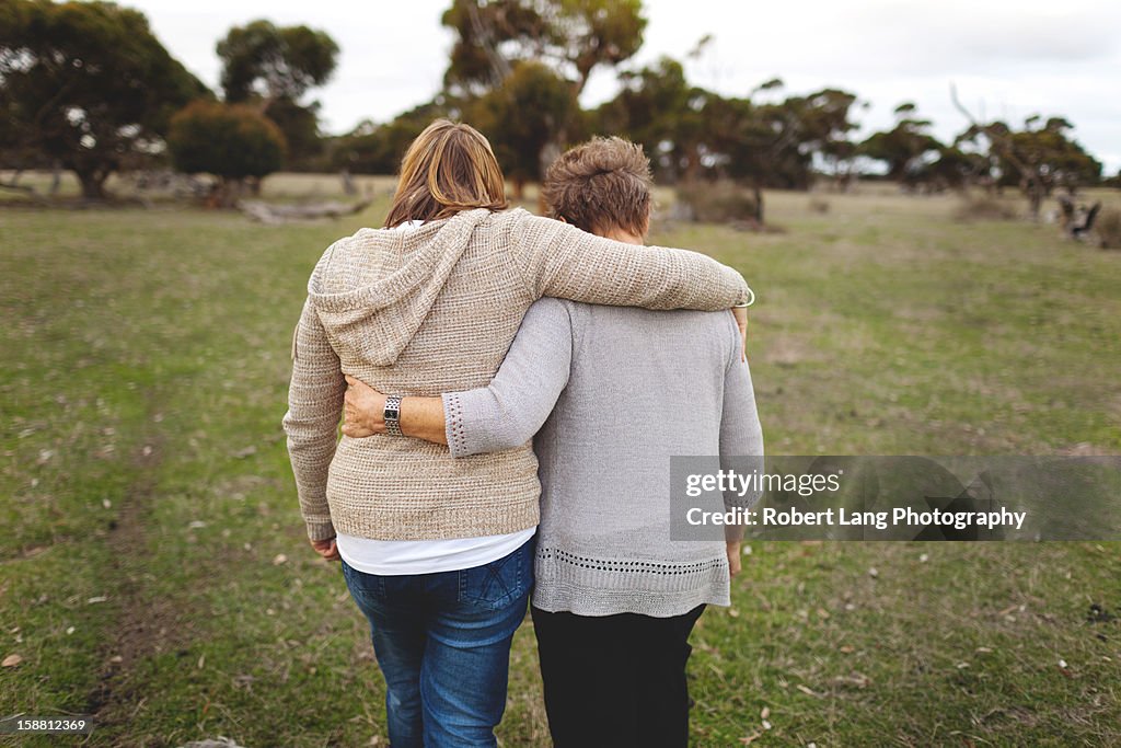 Mother and daughter walking embrace