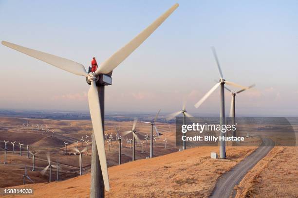 worker standing on wind turbine at wind farm - producción de combustible y energía fotografías e imágenes de stock