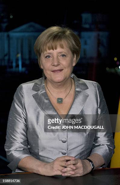 German Chancellor Angela Merkel poses for photographers after the recording of her annual New Year's speech at the Chancellery in Berlin on December...