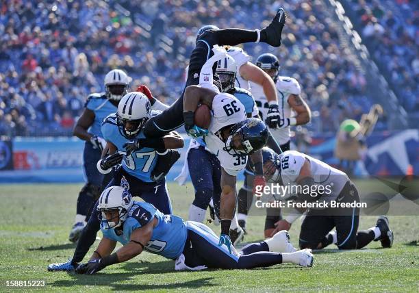 Richard Murphy of the Jacksonville Jaguars is turned head-over-heels by Tommie Campbell and Al Afalava of the Tennessee Titans by at LP Field on...