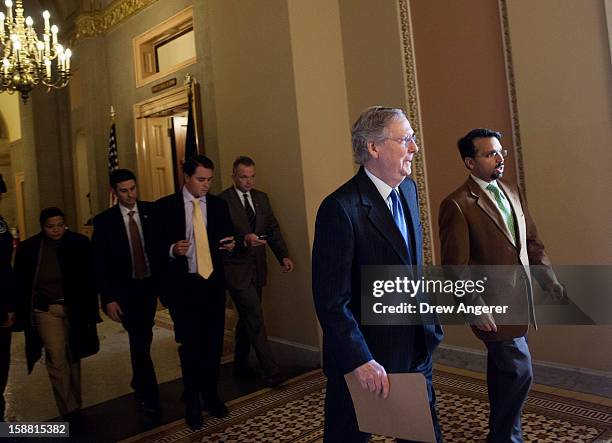 Senate Minority Leader Mitch McConnell walks with an aide toward the Senate Chamber on Capitol Hill December 30, 2012 in Washington, DC. The House...