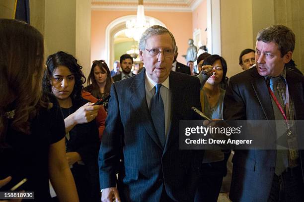 Senate Minority Leader Mitch McConnell walks with reporters on his way to a meeting with Republicans on Capitol Hill December 30, 2012 in Washington,...