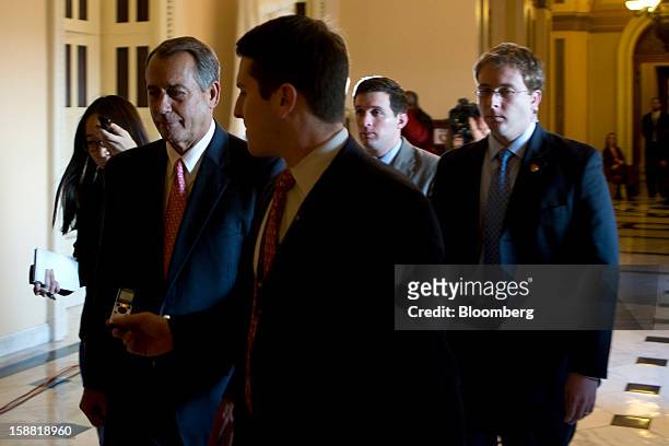 House Speaker John Boehner, a Republican from Ohio, second left, is surrounded by members of the media as he walks through the U.S. Capitol in...