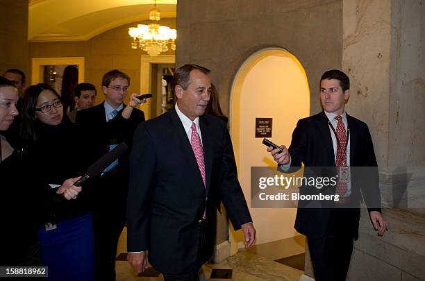 House Speaker John Boehner, a Republican from Ohio, center, is followed by members of the media as he walks through the U.S. Capitol in Washington,...