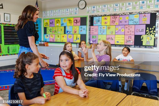 Elementary teacher instructing students in class Elementary teacher instructing students in class