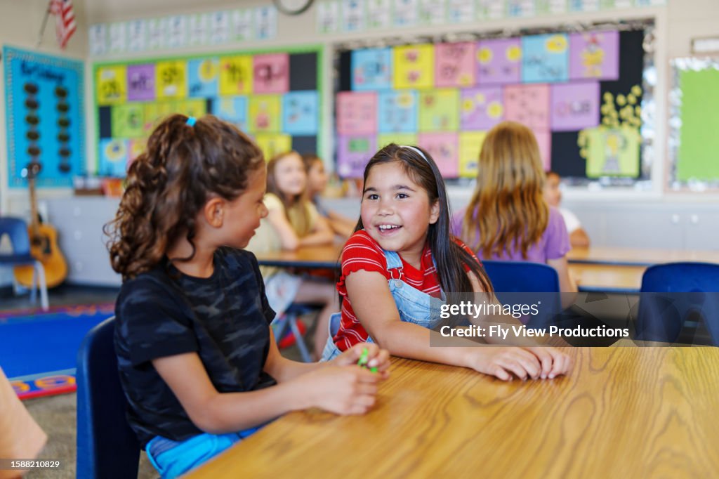 Happy girls talking together at school
