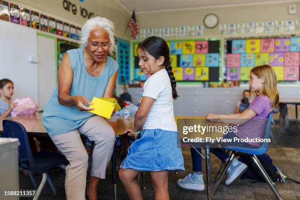 teacher helping elementary age student during class - asian school teacher stock pictures, royalty-free photos & images