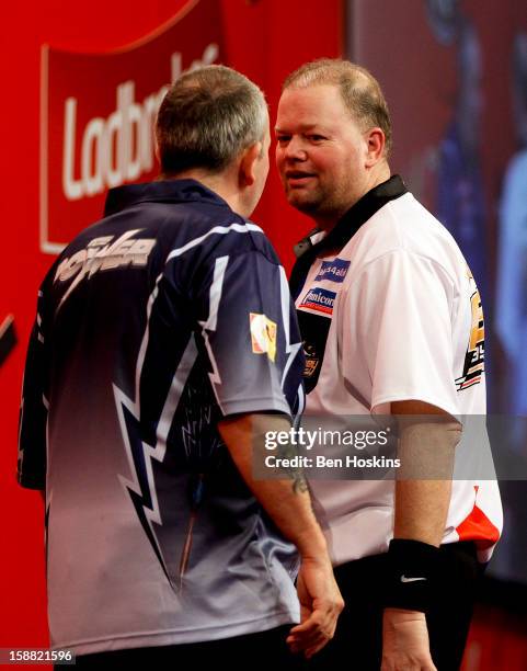 Raymond van Barneveld of the Netherlands and Phil Taylor of England clash during their semi final match on day fourteen of the 2013 Ladbrokes.com...