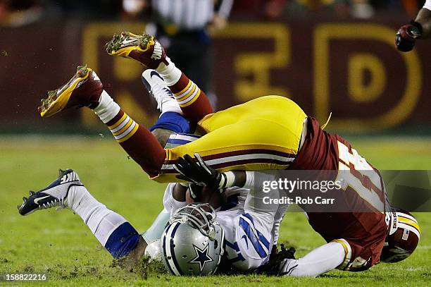 Madieu Williams of the Washington Redskins tackles Dwayne Harris of the Dallas Cowboys after a pass reception in the second quarter at FedExField on...