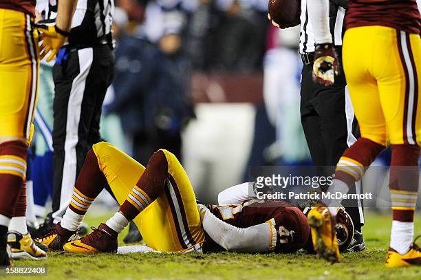Madieu Williams of the Washington Redskins lays on the field after he was injured on the play against the Dallas Cowboys in the second quarter at...