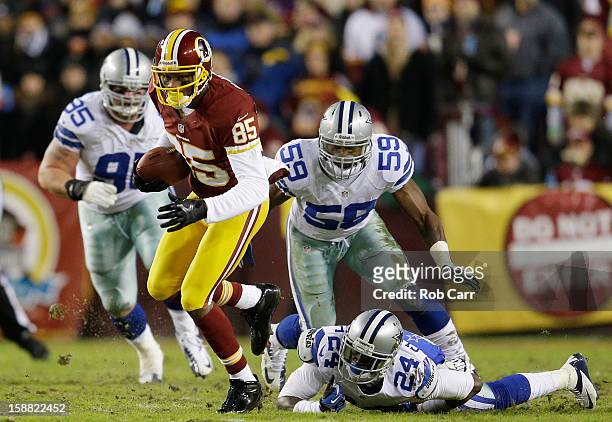 Leonard Hankerson of the Washington Redskins carries the ball against the defense of Morris Claiborne and Ernie Sims of the Dallas Cowboys at...
