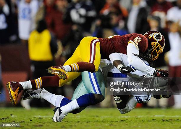 Madieu Williams of the Washington Redskins tackles Dwayne Harris of the Dallas Cowboys after a pass reception in the second quarter at FedExField on...