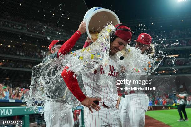 Bryson Stott and Alec Bohm of the Philadelphia Phillies pour water on Michael Lorenzen after he threw a no-hitter against the Washington Nationals at...