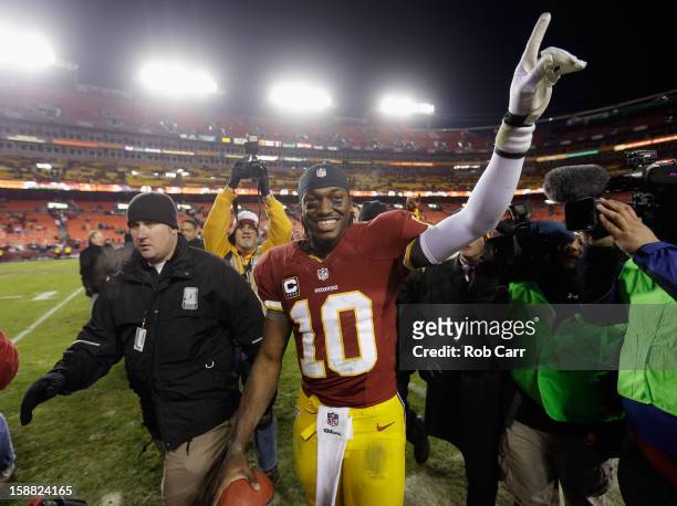 Quarterback Robert Griffin III of the Washington Redskins celebrates after the Redskins defeated the Dallas Cowboys 28-18 at FedExField on December...