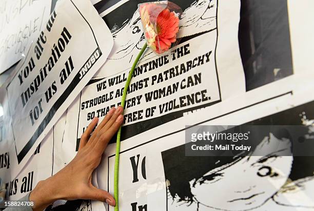 Girl places a flower at a makeshift memorial to mourn the death of a 23-year-old gang rape victim near a bus stop at Munirka in New Delhi on...