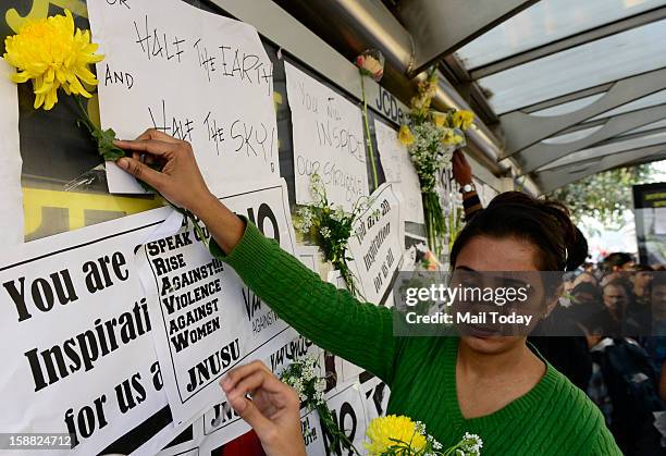 Girl places a flower at a makeshift memorial to mourn the death of a 23-year-old gang rape victim near a bus stop at Munirka in New Delhi on...