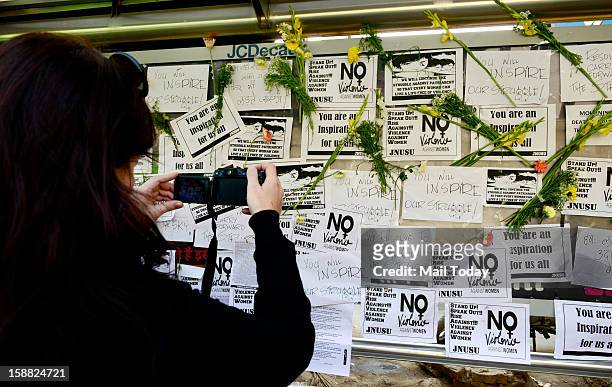 Girl taking picture of a makeshift memorial to mourn the death of a 23-year-old gang rape victim near a bus stop at Munirka in New Delhi on Saturday....