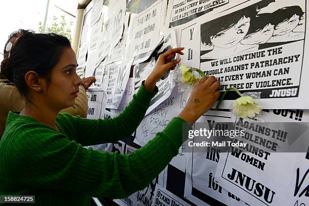 Girl places a flower at a makeshift memorial to mourn the death of a 23-year-old gang rape victim near a bus stop at Munirka in New Delhi on...