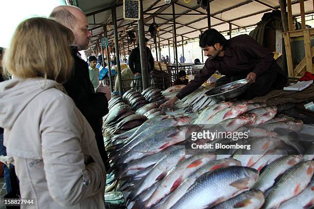 Fishmonger arranges fish for sale at a market in Islamabad, Pakistan, on Sunday, Dec. 30, 2012. Pakistan’s economy will probably expand 3.5 percent...