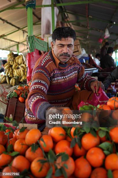 Vendor chooses fruits for sale at a market in Islamabad, Pakistan, on Sunday, Dec. 30, 2012. Pakistan’s economy will probably expand 3.5 percent in...