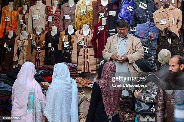 Women browse clothing at a market in Rawalpindi, Pakistan, on Sunday, Dec. 30, 2012. Pakistan’s economy will probably expand 3.5 percent in the 12...