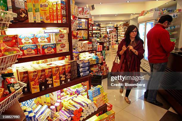 Woman walks past shelves of packaged foods at Shams supermarket in Islamabad, Pakistan, on Sunday, Dec. 30, 2012. Pakistan’s economy will probably...