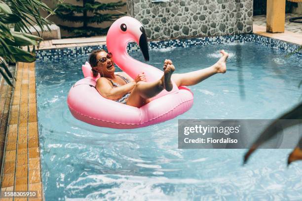 middle age woman swimming in the pool with inflatable swim ring - candid stock pictures, royalty-free photos & images
