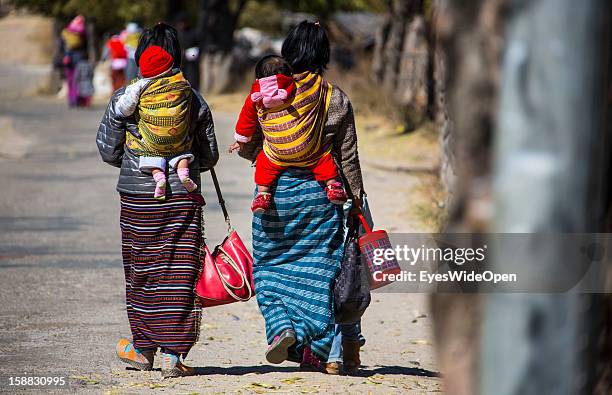 Women and children in traditional Kira dress on the way to the market or shopping near the Temple of Kurjey Lhakhang near Jakar on November 18, 2012...