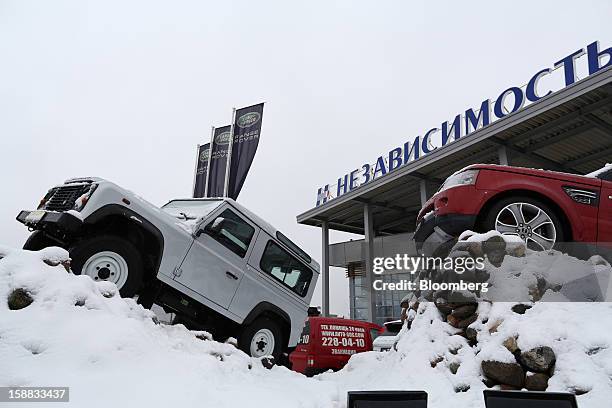 Land Rover automobiles stand on display surrounded by snow outside an independent auto showroom in Moscow, Russia, on Friday, Dec. 28, 2012. Tata...