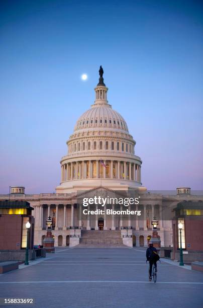 Cyclist rides toward the U.S. Capitol in Washington, D.C., U.S., on Monday, Dec. 31, 2012. U.S. Lawmakers hurtled toward a midnight deadline to avert...