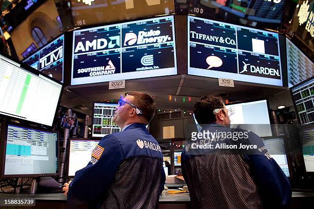 Traders wear 2013 New Years party glasses while they work on the floor of the New York Stock Exchange December 31, 2012 in New York City. US...