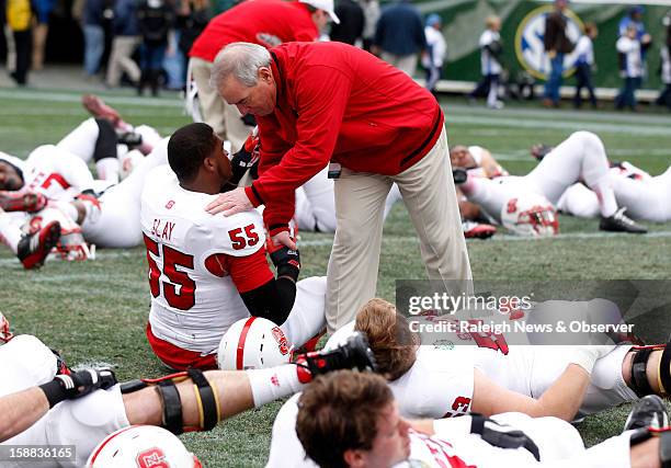 State interim coach Dana Bible shakes hands with defensive end Brian Slay before the Wolfpack's game against Vanderbilt in the Franklin American...