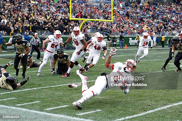 Tobais Palmer of the North Carolina State Wolfpack gets tripped up on a kick return against the Vanderbilt Commodores during the Franklin American...