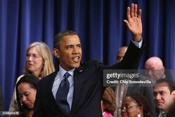 President Barack Obama waves goodbye after delivering remarks about the fiscal cliff negotiations in the Eisenhower Executive Office Building next to...