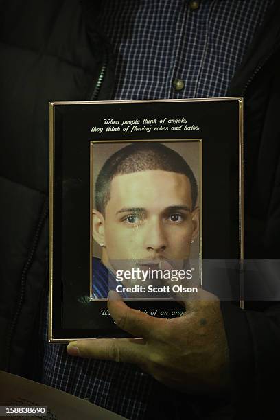 Pascual Nunez holds a picture of his stepson Harry Rodriguez during a press conference he attended with other family members of murder victims on...