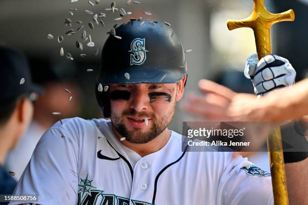 Cal Raleigh of the Seattle Mariners celebrates in the dugout with teammates after hitting a two-run home run during the sixth inning against the...