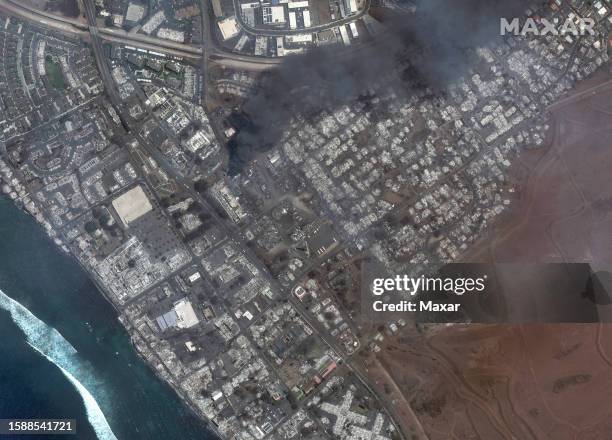 Maxar satellite imagery showing total destruction of the Lahaina square and outlets after the Lahaina Wildfire, with one building still actively...