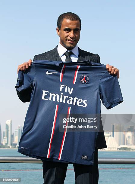 New signing Lucas Moura of PSG poses with a shirt as he is officially unveiled as a player of Paris Saint-Germain during a press conference and...